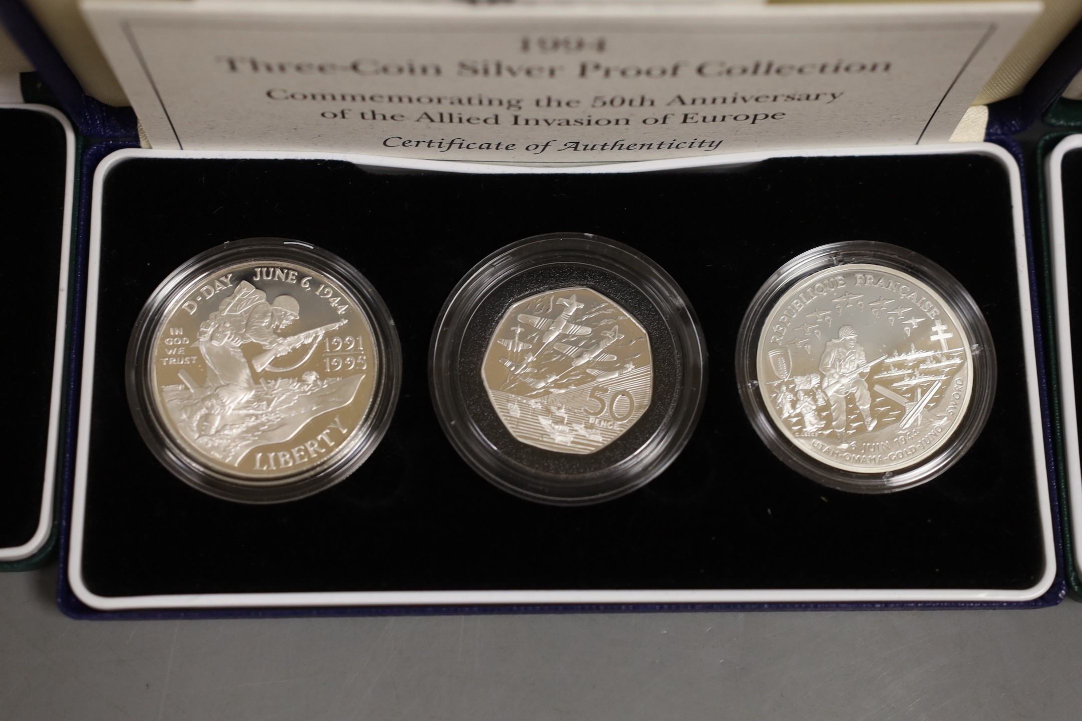 Cased Royal Mint UK silver proof coins – 2006 Victoria Cross two 50 pence, HM Queen silver jubilee two crown set and a 1994 three coin collection commemorating the 50th anniversary of the allied invasion of Europe (3 set